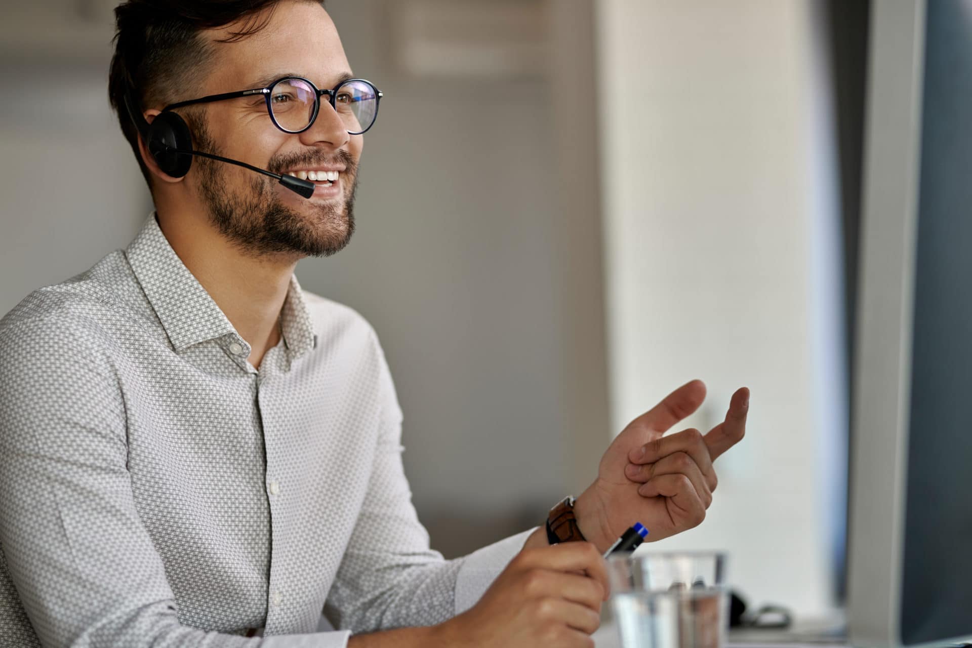 happy call center agent using computer while communicating with clients working office